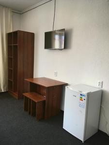 乔尔蓬阿塔Гостевой дом Крылья的办公室设有书桌和小冰箱