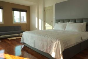 曼谷Riverfront house/Chao phraya river/Baan Rimphraya的卧室配有一张白色的大床和一张沙发。