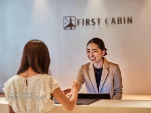 大阪First Cabin Nishi Umeda的和桌子上的女人握手