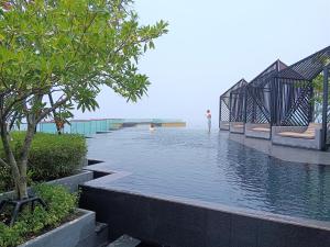 芭堤雅市中心Edge Central Pattaya Lux的水池,水中有人站在水中