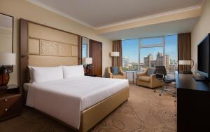 阿斯塔纳SAAD Hotel Astana的酒店客房配有一张床、一张书桌和一台电视。