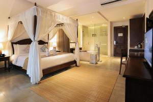 乌布乌布维萨斯度假酒店的一间卧室设有一张天蓬床和一间浴室。