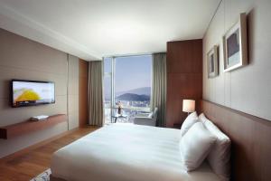 济州市LOTTE City Hotel Jeju的酒店客房设有一张大床和一台电视。