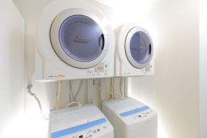 东京MYSTAYS 蒲田酒店的客房内的2台洗衣机和1台洗衣机
