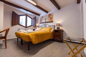阿巴迪亚圣萨尔瓦托雷La Corteccia del Faggio的一间卧室配有一张带黄色床罩的大床