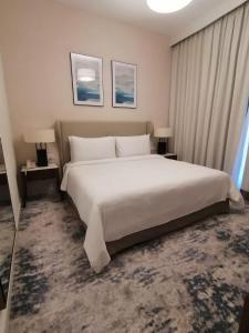 SharmThree Bedroom Apartment at Address Residence Fujairah的卧室配有一张白色大床和两盏灯。