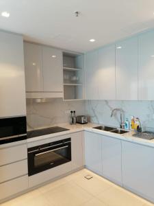 SharmThree Bedroom Apartment at Address Residence Fujairah的厨房配有白色橱柜和水槽