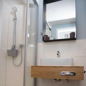 诺德奈Villa Westend的浴室配有盥洗盆和带镜子的淋浴