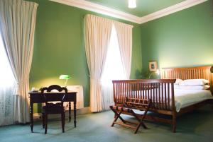 布罗肯希尔帝国精品公寓式酒店的一间卧室配有一张床和一张带台灯的书桌