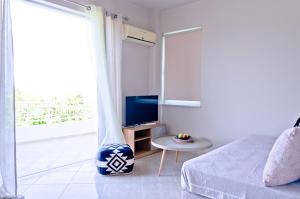 加藤-达拉特索Barbaras Apartments的一间卧室配有一张床、一台电视和一张桌子