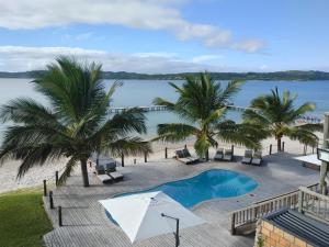 普拉伊拉多比莱尼Mukumbura Lodge Bilene的拥有游泳池、棕榈树和水的度假胜地