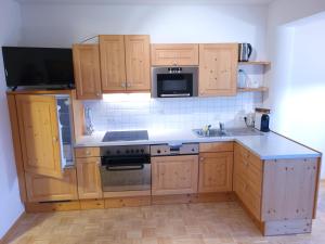 RantenLandhaus Zitz的厨房配有木制橱柜和炉灶烤箱。
