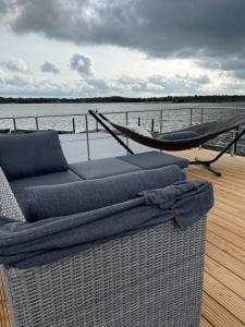 石勒苏益格Hausboot Fjord Schleiliebe mit Biosauna und Dachterrasse in Schleswig的船上甲板上的沙发