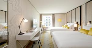 皮托巴黎拉德芳斯万丽酒店的酒店客房配有两张床和一张书桌