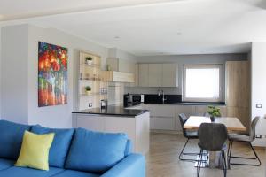 卡瓦莱塞CASA YARA - Dolomiti Affitti的一间带蓝色沙发的客厅和一间厨房