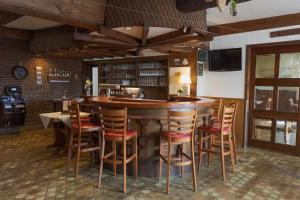 霍夫比伯Gasthof Sondergeld的餐厅的酒吧,带木凳
