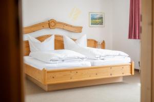 霍夫比伯Gasthof Sondergeld的一间卧室配有带白色枕头的木床