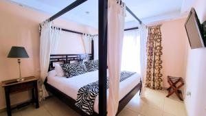 塞博河畔卡莱塔Evita Beach Suites Exclusivas的卧室配有黑白天蓬床