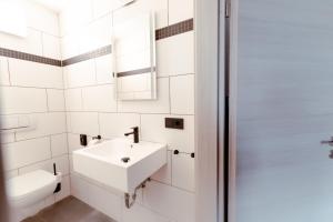 德累斯顿Restaurant und Pension Alberthafen的白色的浴室设有水槽和卫生间。