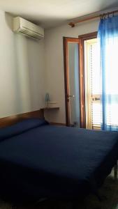 罗萨岛piccolo monolocale al porticciolo的一间卧室设有蓝色的床和窗户。