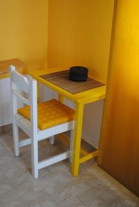 阿凡杜Karmik Concept Apartments的黄色桌子和椅子,上面有碗