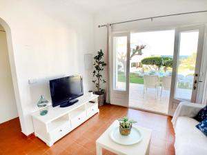 蓬塔格罗萨La Casa del Jardin. Menorca的一间带电视和沙发的客厅