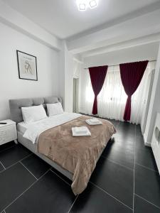 苏恰瓦Cozy Aparthotel - Central City Suceava的一间卧室配有一张带红色窗帘的大床