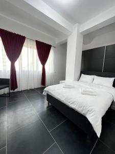 苏恰瓦Cozy Aparthotel - Central City Suceava的一间卧室配有一张带红色窗帘的大床