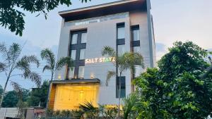 古尔冈Saltstayz Basil - Near Golf Course Road & Extension Road的一座高大的白色建筑,有一道灯