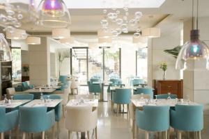 赫索尼索斯格拉罗斯海滩酒店的一间设有蓝色和白色桌椅的餐厅