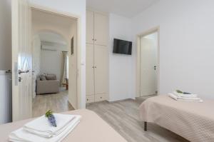 米科利维亚Orkos Naxian Wave 2的白色的客房配有两张床和电视。