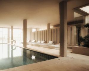 阿尔塔Es Racó d´Artà的一座带沙发的建筑中的游泳池和一个游泳池