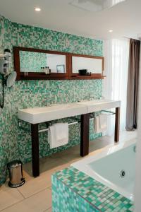 波尔图波罗Le Golfe的浴室配有盥洗盆和浴缸。
