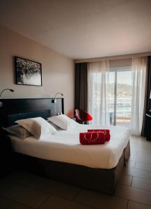 波尔图波罗Le Golfe的一间卧室配有一张大床,上面有红色毛巾