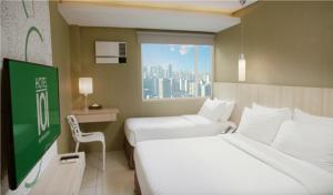 马尼拉Hotel101 - Fort的酒店客房设有两张床和窗户。