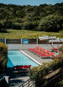 波尔图波罗Le Golfe的一个带红色椅子和一束桌子的游泳池