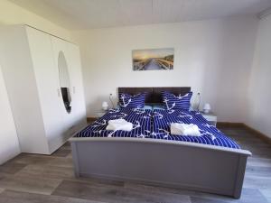 GarzFerienwohnung Am Stadtrand Garz Rügen的一间卧室配有一张蓝色和白色条纹的床