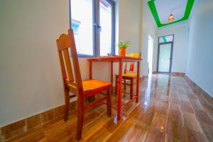 峰牙Phong Nha Magic Fingers Homestay and Spa的窗户房间里的小桌子和椅子