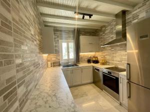 凯勒里瓦迪Infinity View Villas Mykonos的一间厨房,配有白色家电和砖墙