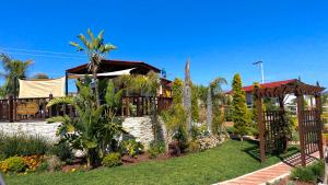 恩塞纳达港Paraíso del Valle的一座带树木和植物的花园的房子