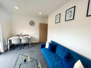 伯恩茅斯Lorne Park Road, Bournemouth的客厅配有蓝色的沙发和桌子