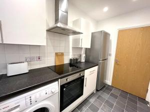 伯恩茅斯Lorne Park Road, Bournemouth的厨房配有冰箱、洗衣机和烘干机