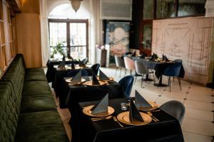 比亚韦斯托克特拉迪西亚别墅的餐厅的一排桌子,有黑桌子和椅子