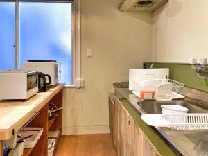 高松コトリ コワーキング&ホステル高松的厨房配有水槽和微波炉