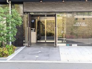 大阪ESLEAD HOTEL Osaka Ebisu的带有玻璃门的办公大楼入口