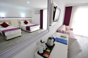 阿萨拉尔Ramira Beach Hotel - All Inclusive的小房间设有两张床和镜子