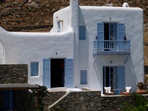 超级天堂海滩那玛别墅酒店的白色的房子设有蓝色的窗户和阳台