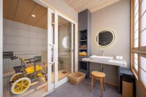 米泽市Tofuya Ryokan, Onogawa Onsen, Sauna, Barrier-free的浴室设有黄色轮椅,靠近水槽