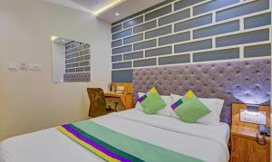孟买Treebo Trend Prince, Mumbai的一间卧室设有一张大床和蓝色的墙壁