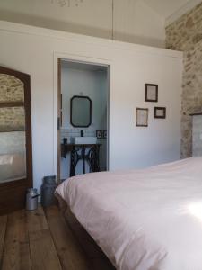 Les Trois Jolies的卧室配有白色的床和镜子